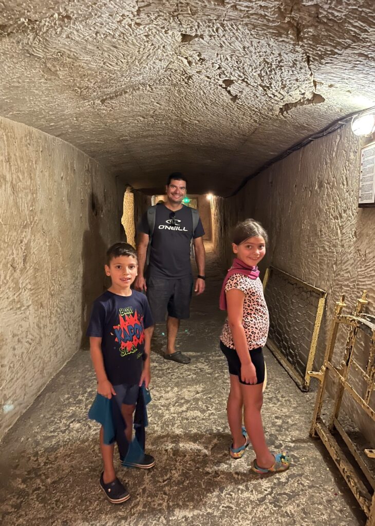 Our kids going through underground tunnels in Mellieha built during WW11. 