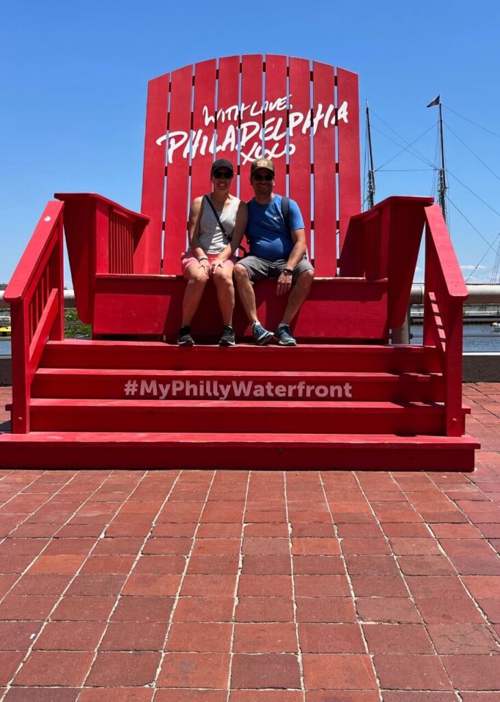 husband and wife sitting in the Big red lawn chair in Philadelphia