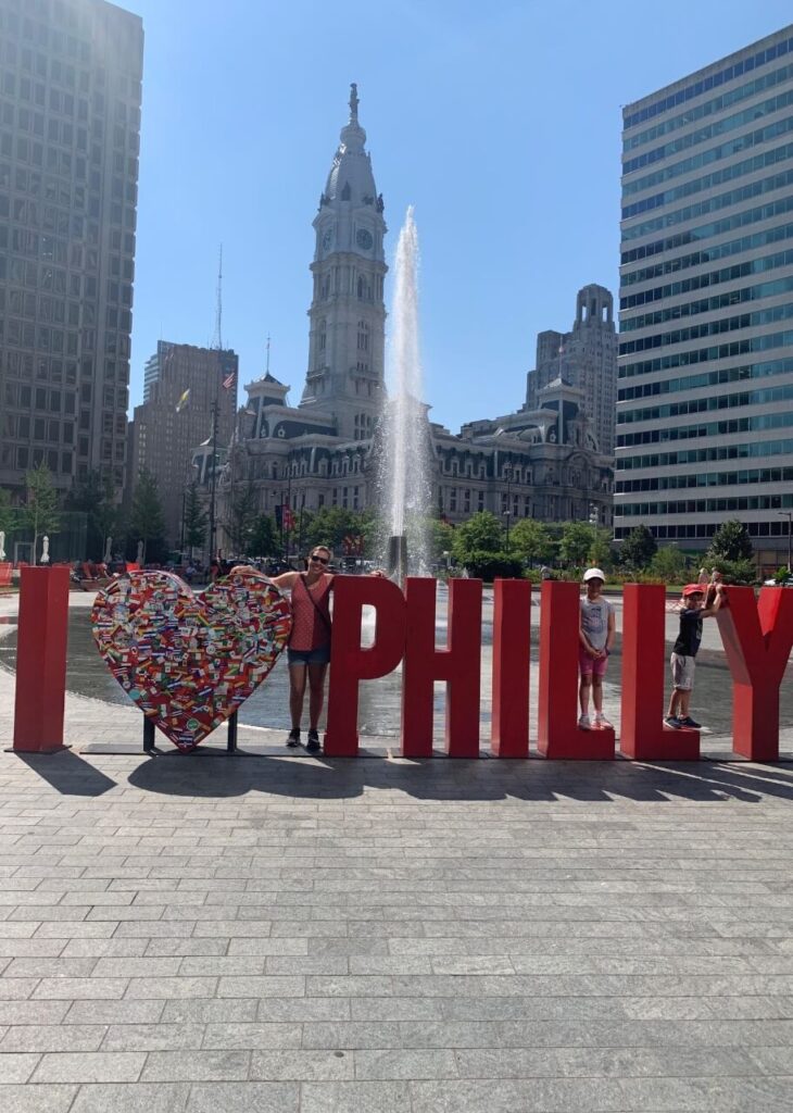 Philadelphia family getaway in Love Park. Sign saying I "heart" Philly.