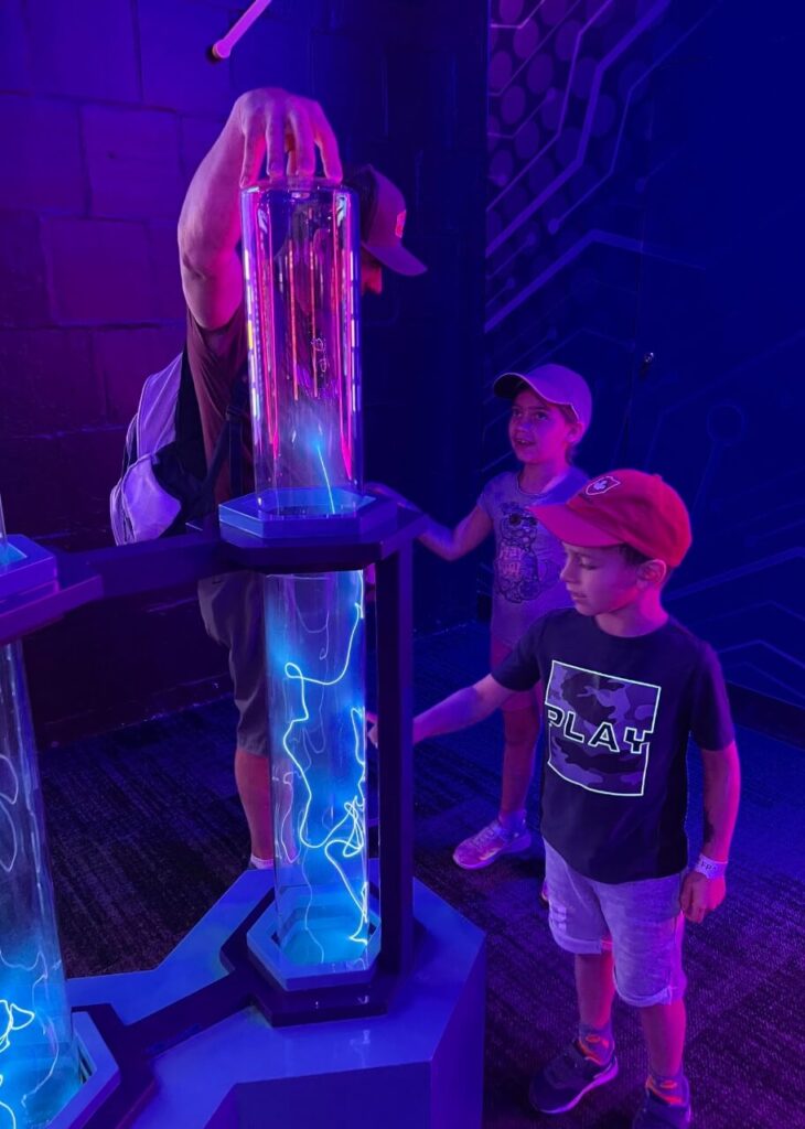 two kids playing at the franklin institute in philadelphia in the electricity section of the museum. 