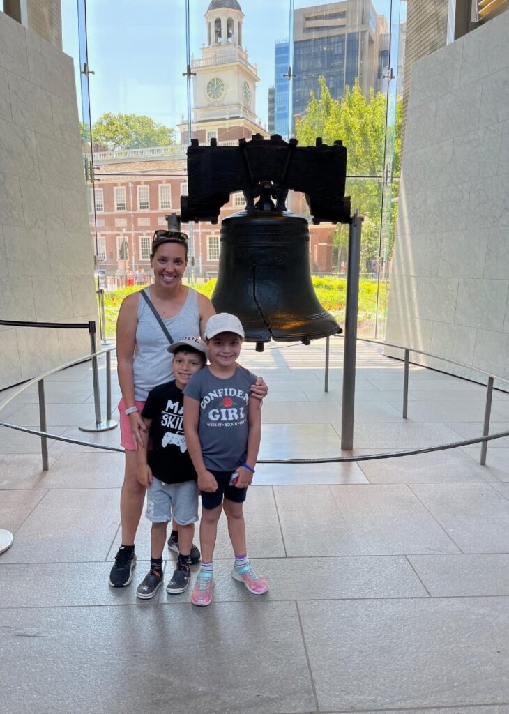 Mom with 2 kids standing in front of the Liberty Bell in Philadelphia