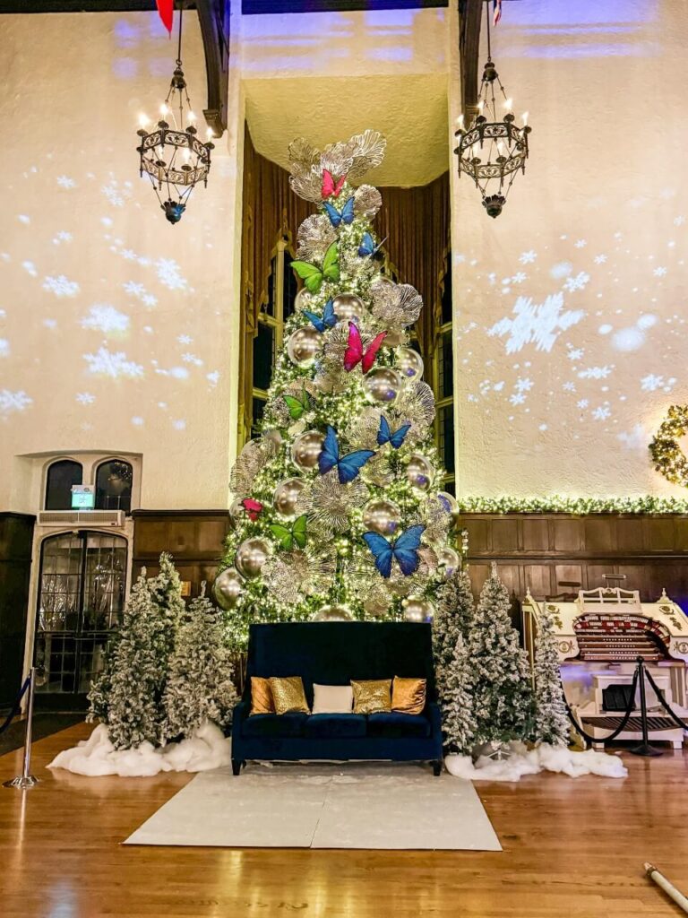 a large lit up christmas tree inside casa loma in toronto