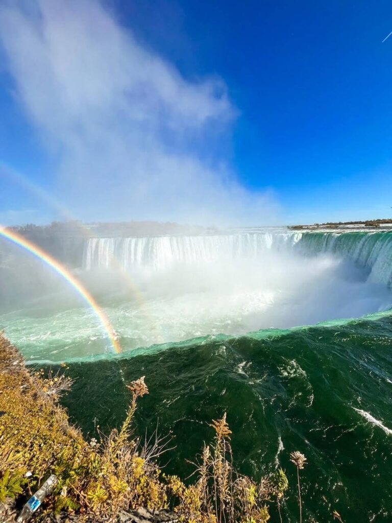 View of Horseshoe Falls from Niagara Falls Canada side. A rainbow over the falls.