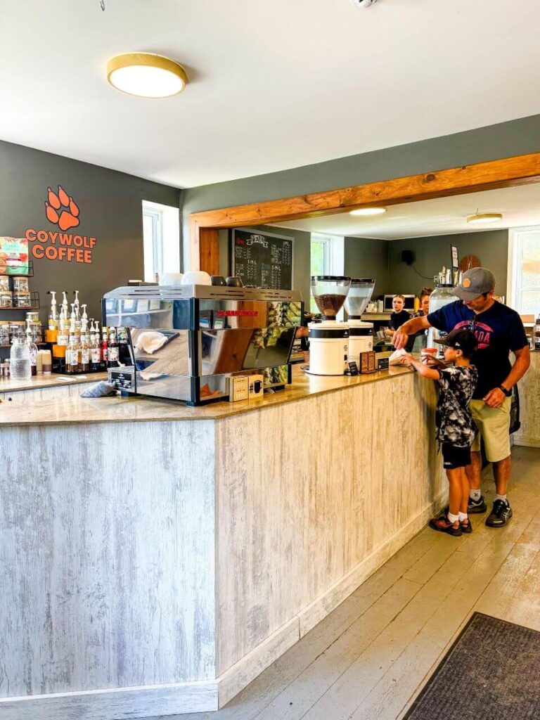 Dad and son standing at the counter at Coywolf Coffee getting served croissants.