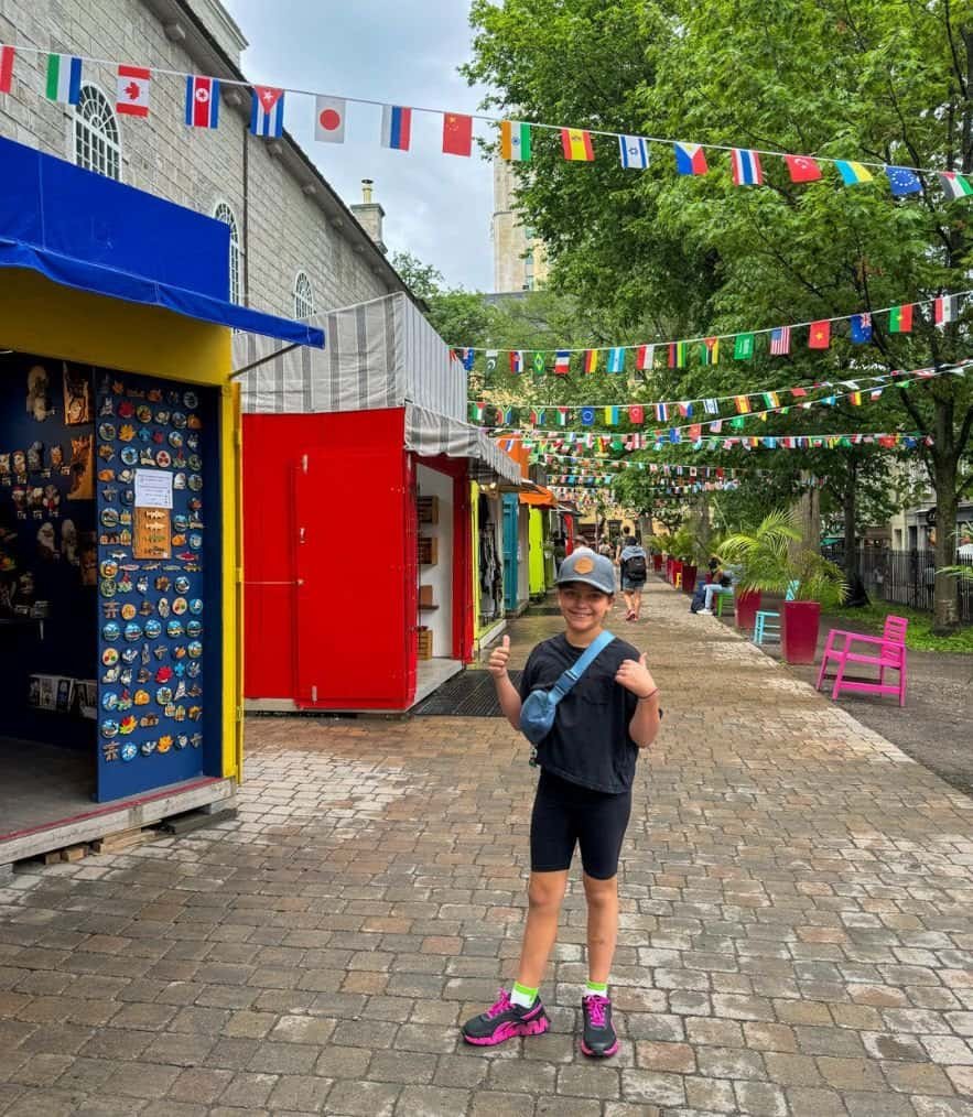 Girl posing beside colourful huts where the artisan markets sell crafts 