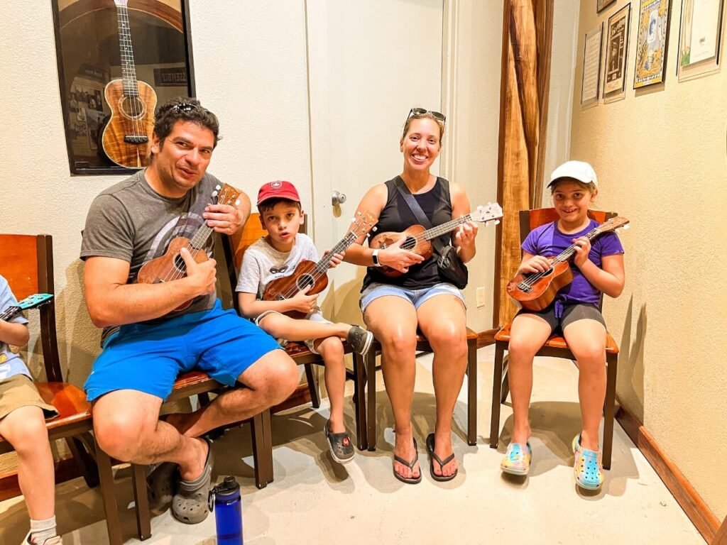 Family of 4 all holding ukuleles during a lesson
