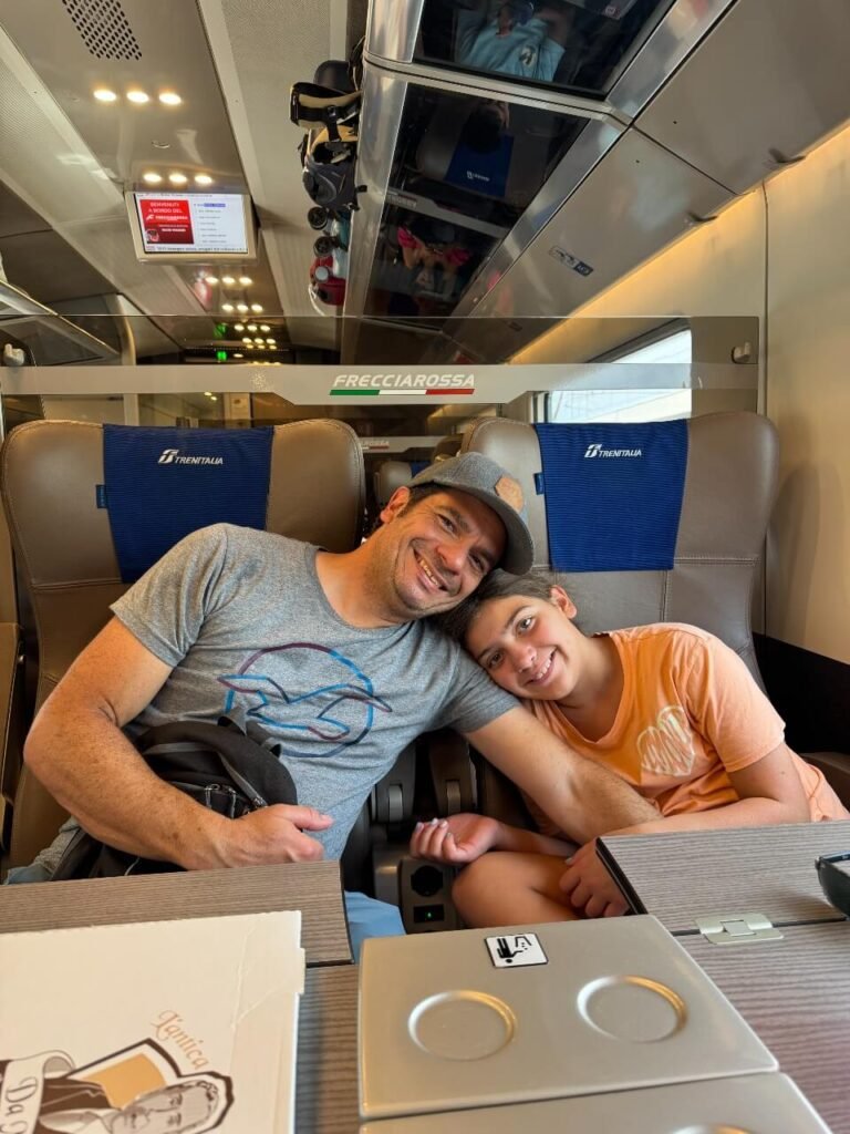 dad and daughter sitting on the high speed train in italy